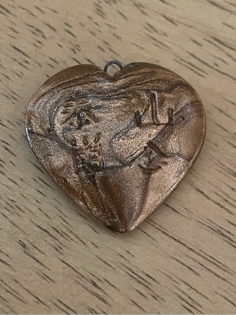 heart-shaped brown gold-toned pendant central embossed figure